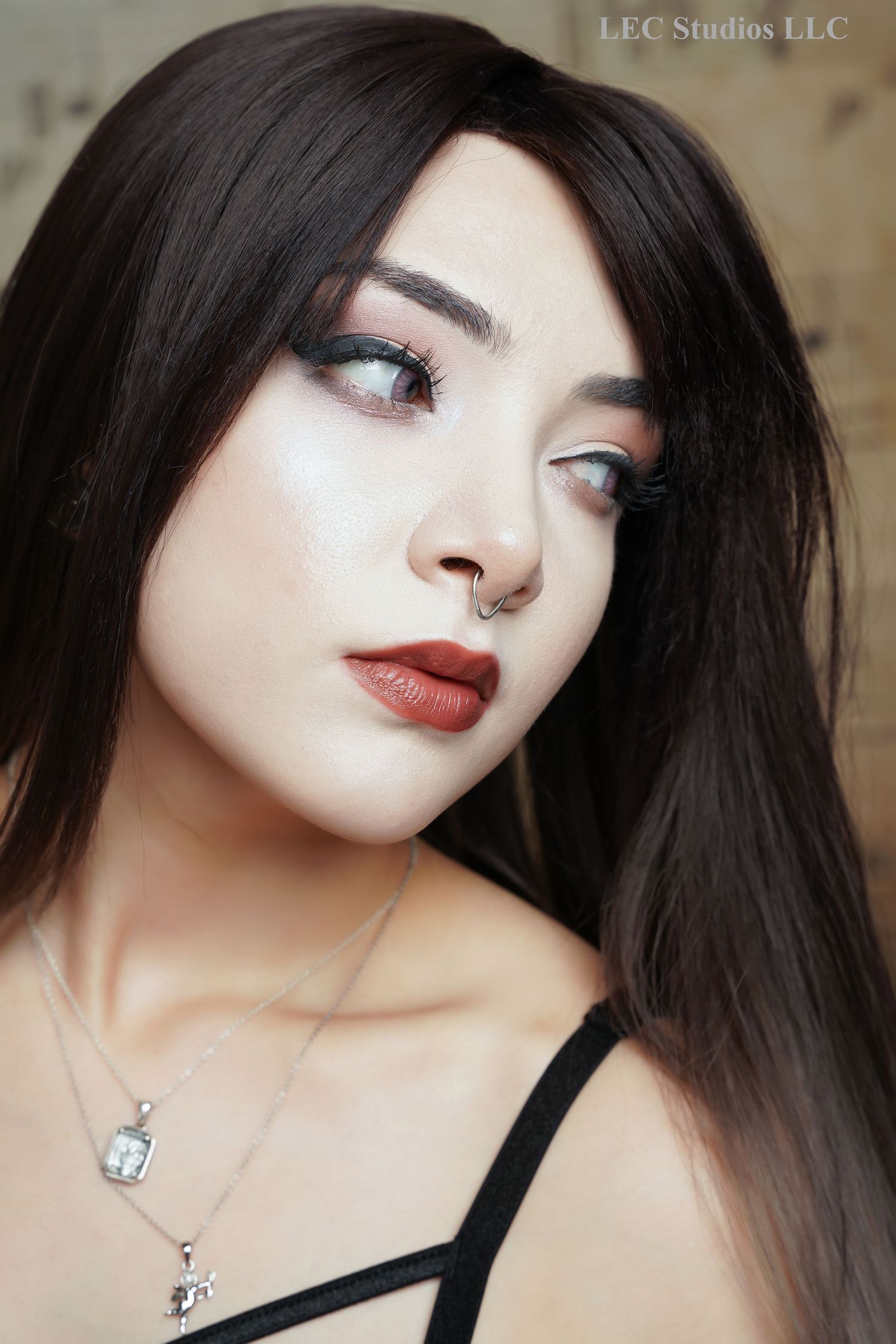 An image of a beautiful lady with long black hair who is looking off to her left