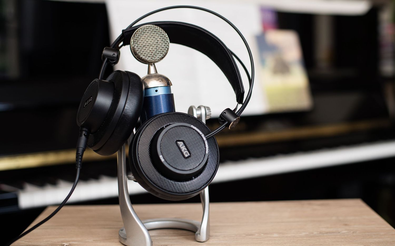 Professional audio headphones displayed on stand against dark background.