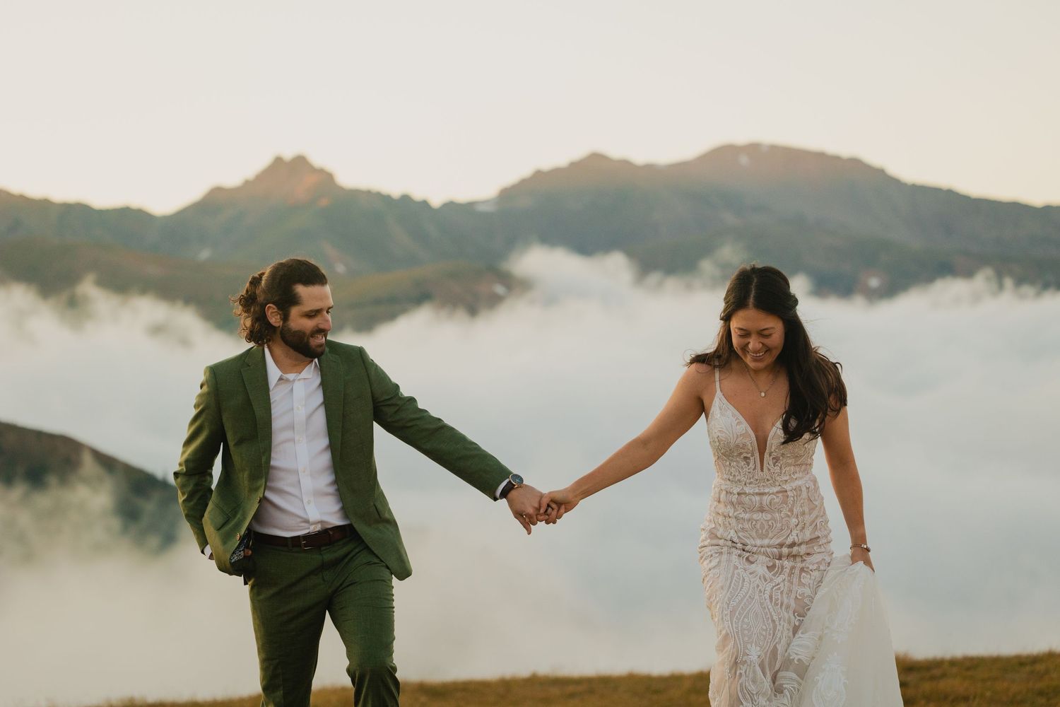 Bride and groom laugh together, surrounded by the stunning natural beauty of Loveland Pass, Colorado