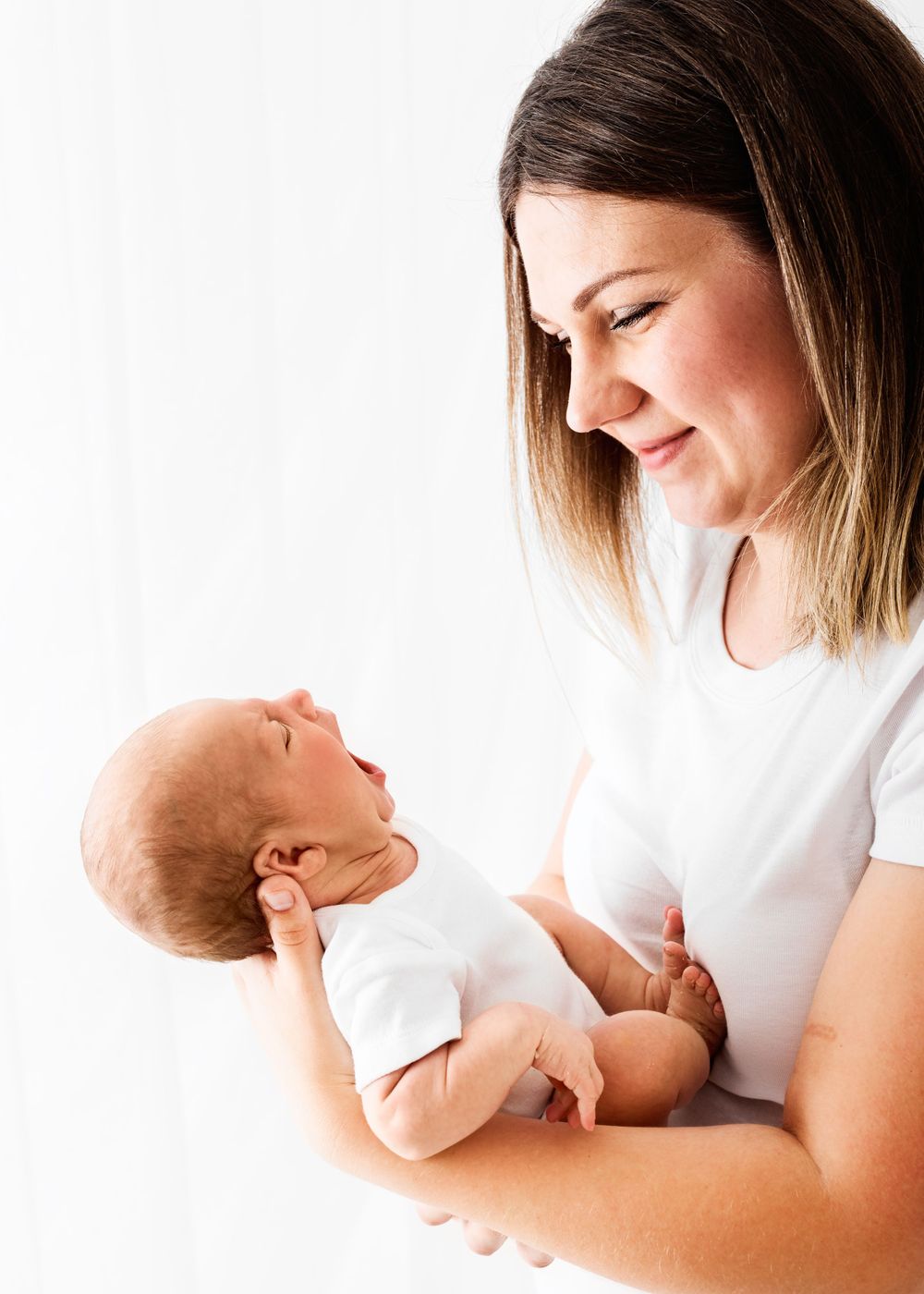 baby lead photo shoot with family in all white studio