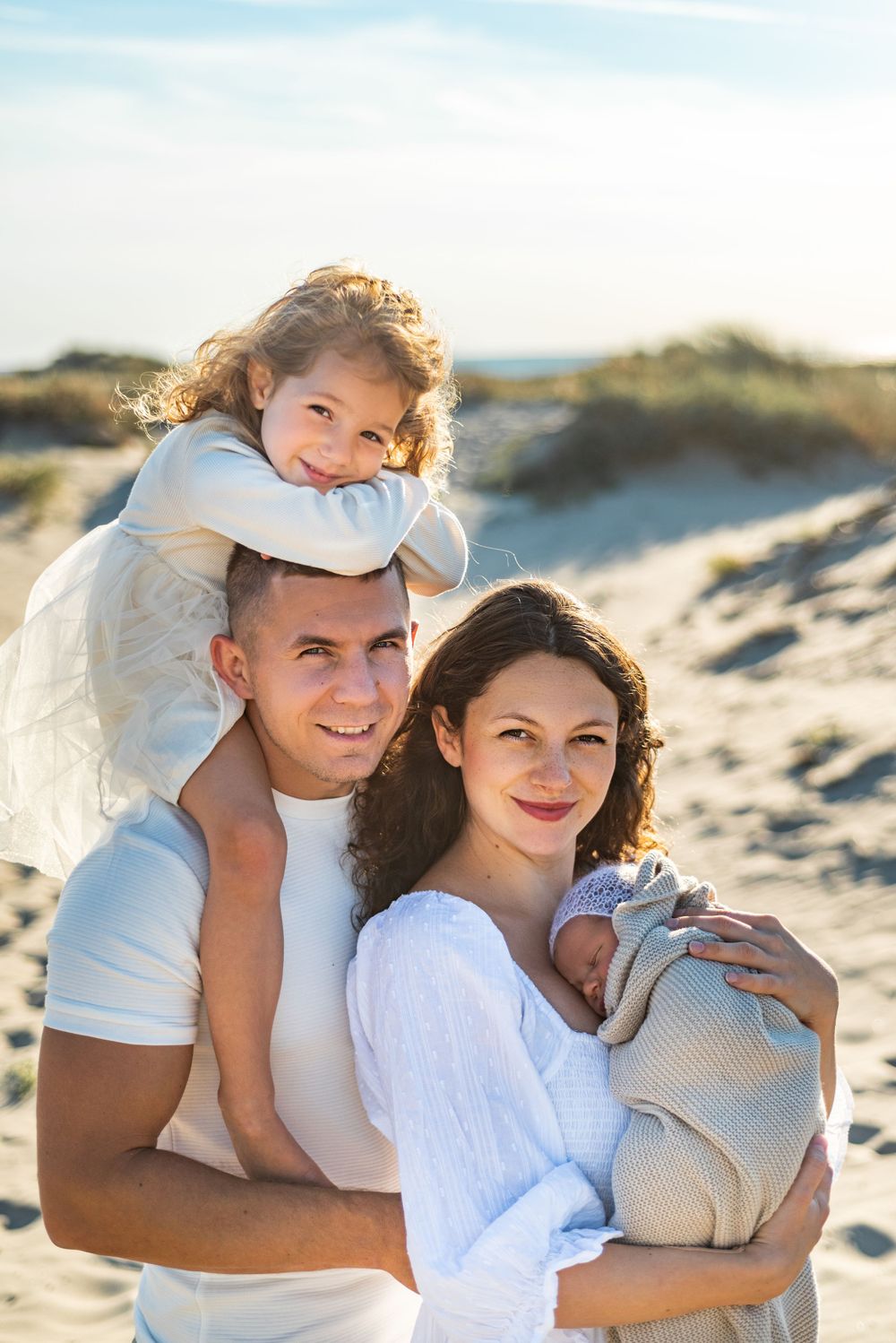 family beach photos with newborn on sand dunes