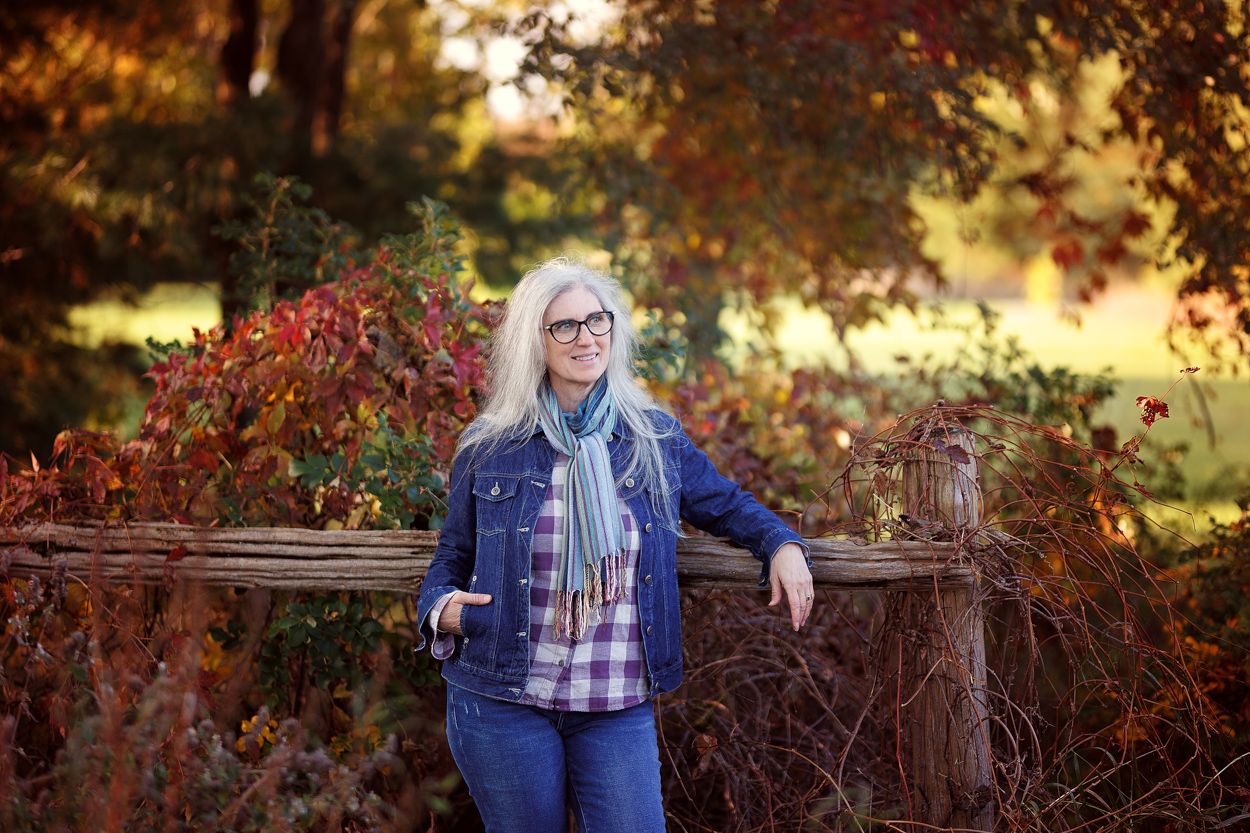 An environmental headshot of a woman in the fall