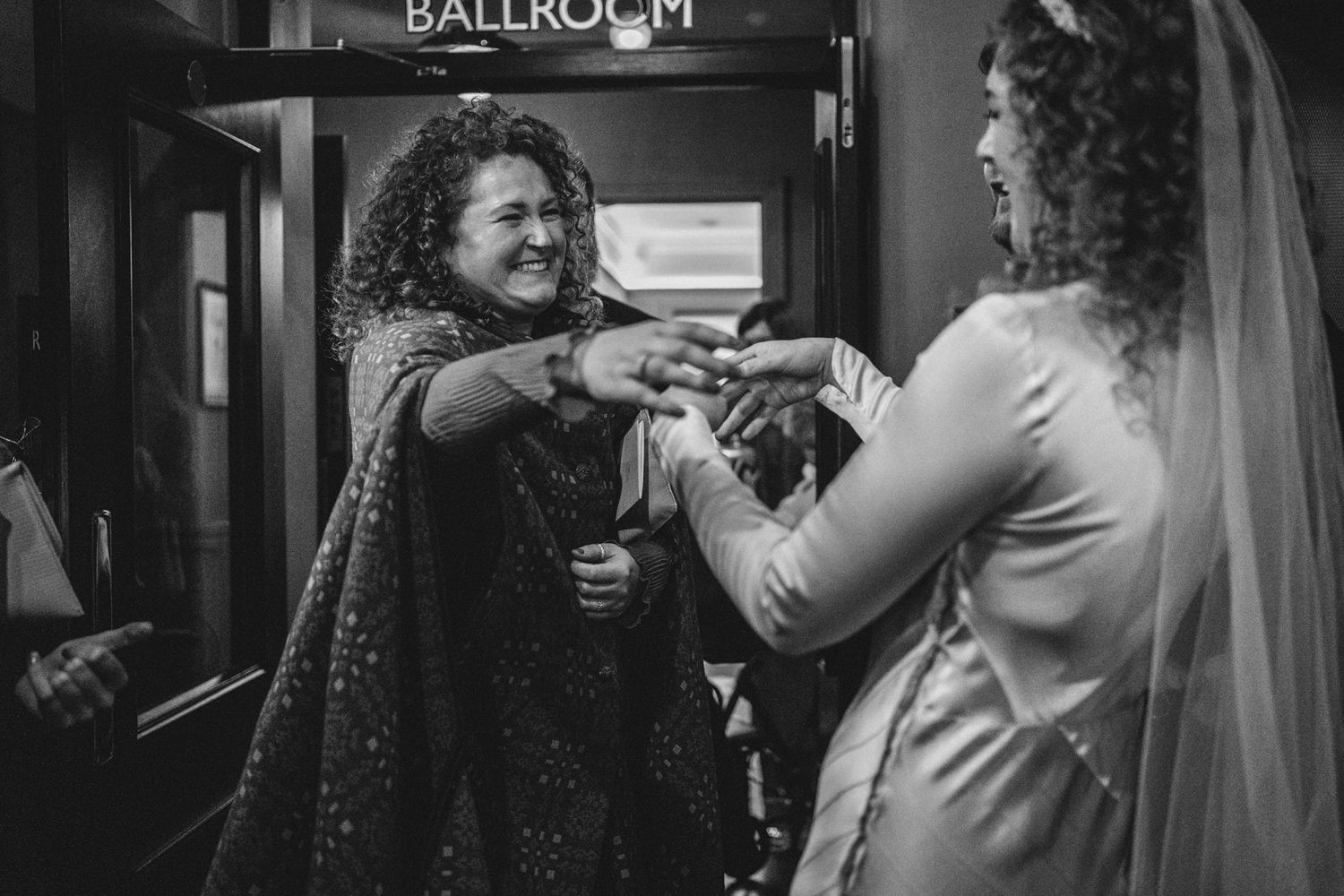 Celebratory moment outside the ballroom as wedding guests share excitement.