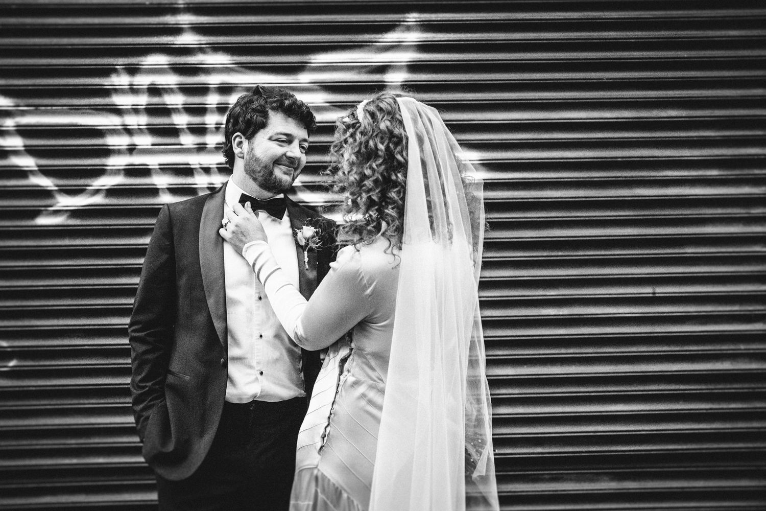 A romantic black and white portrait against an industrial metal backdrop.