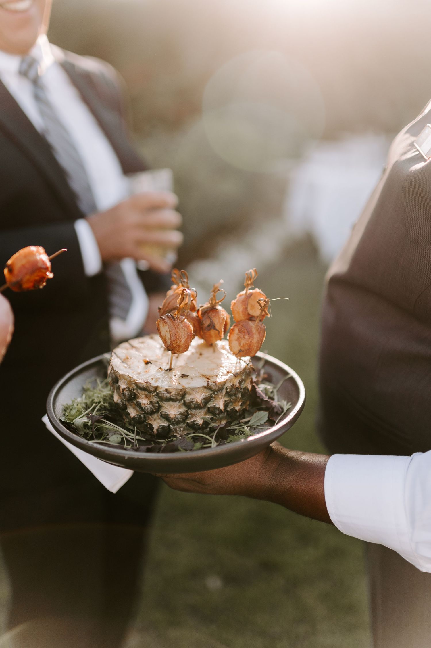 Elegant appetizers being served on silver platters at an upscale event.