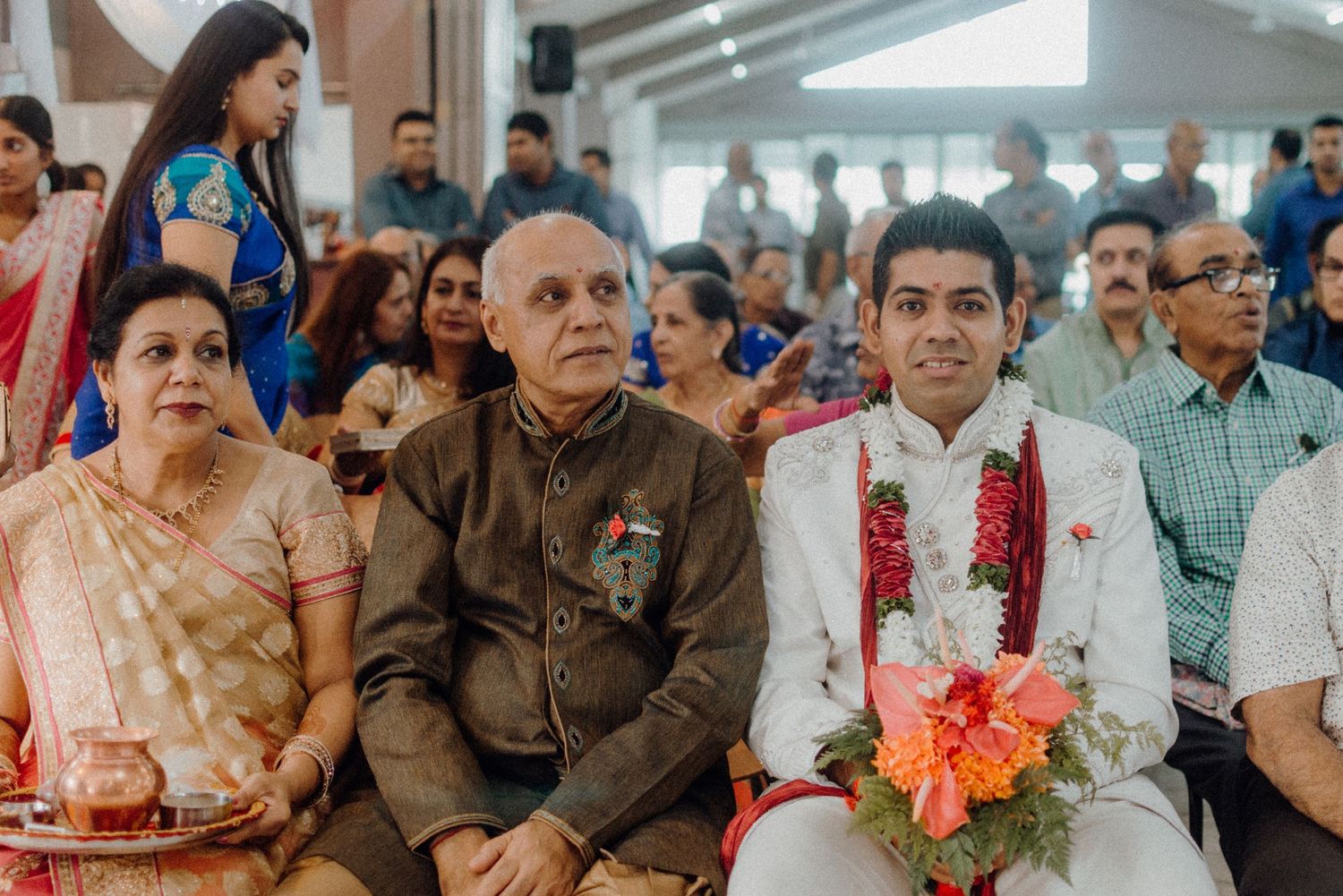 Wedding guests in traditional Indian attire seated during a ceremony.