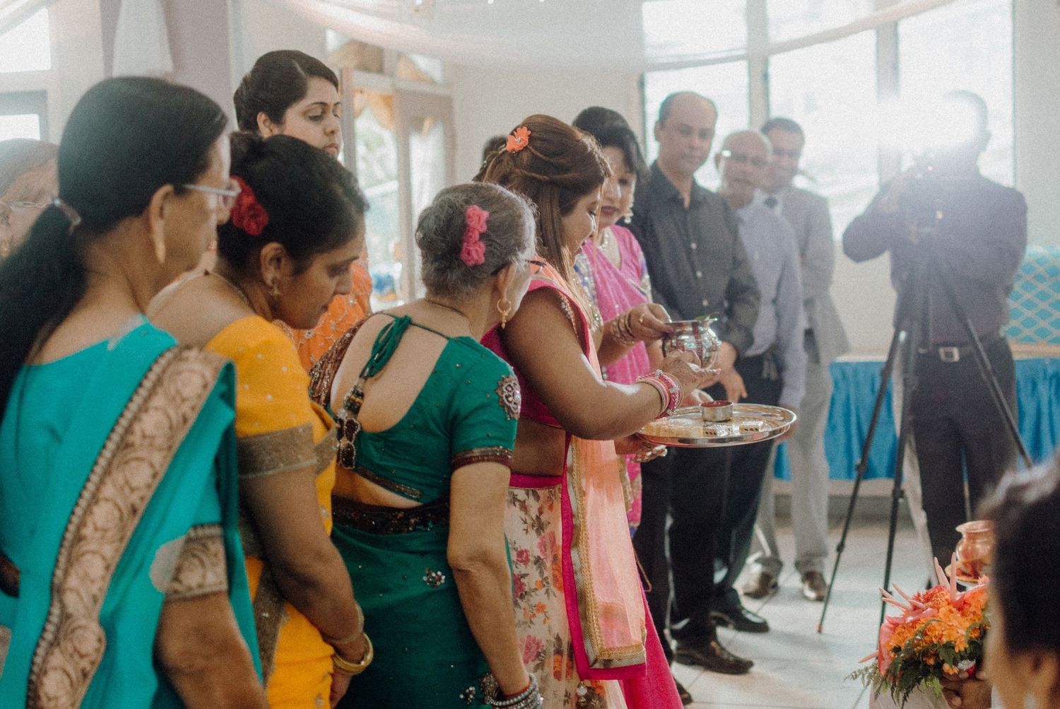 Guests in colorful saris gathered at an indoor celebration event.