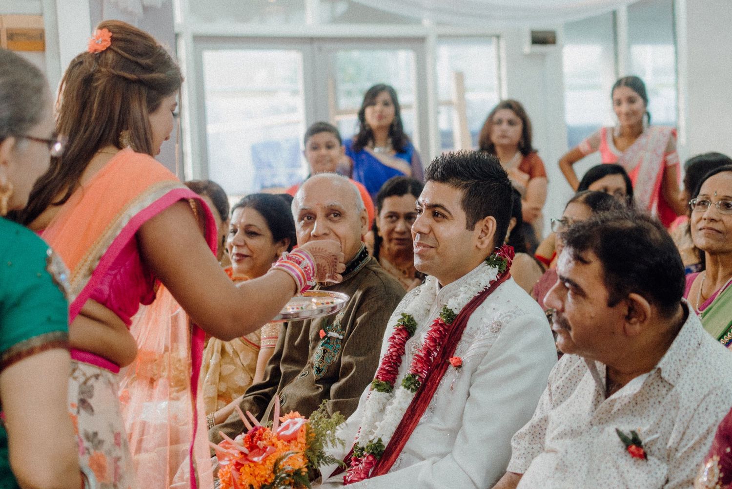 Wedding ceremony guests participating in traditional rituals and blessings.