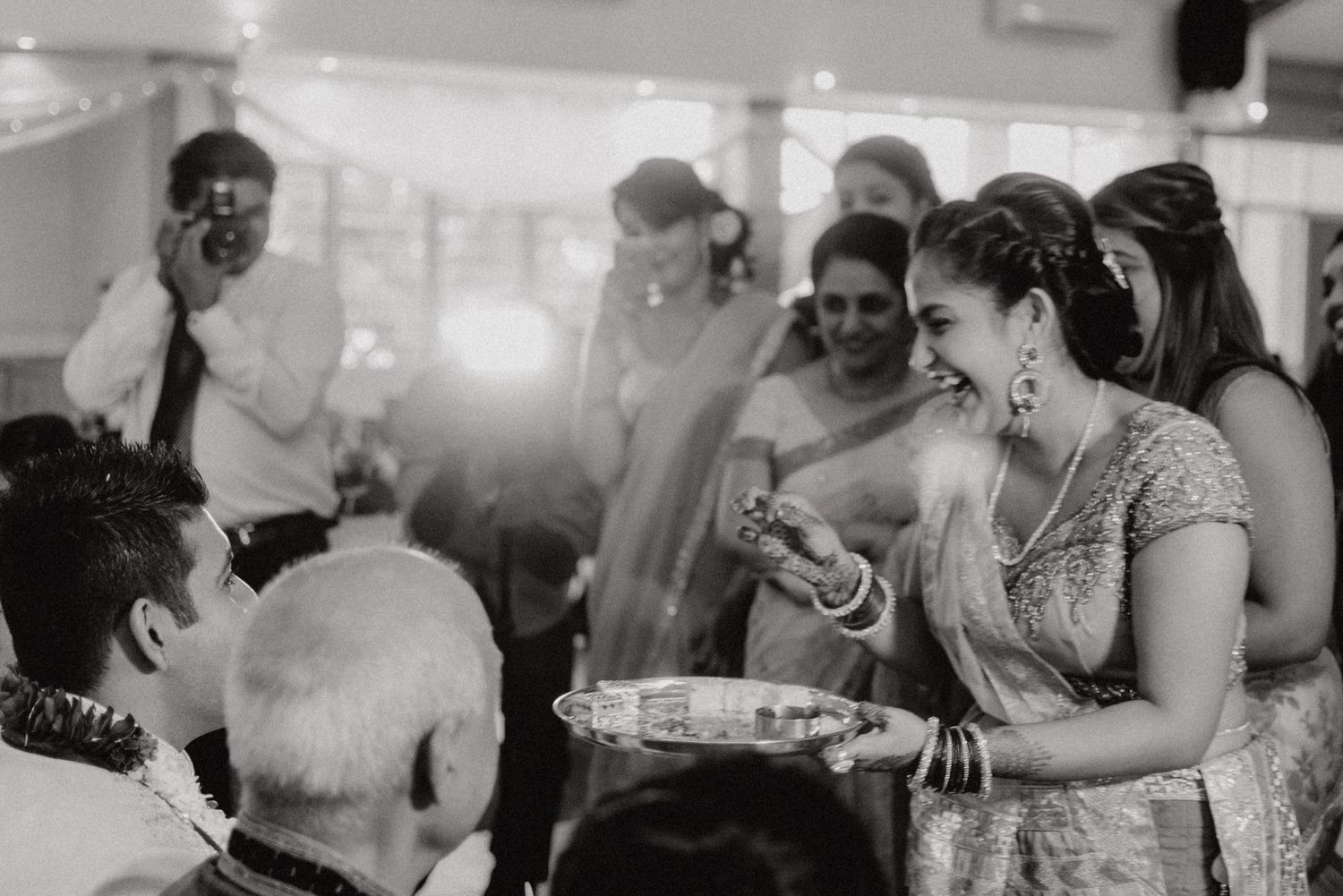 Black and white photo of wedding guests participating in ceremonial traditions.