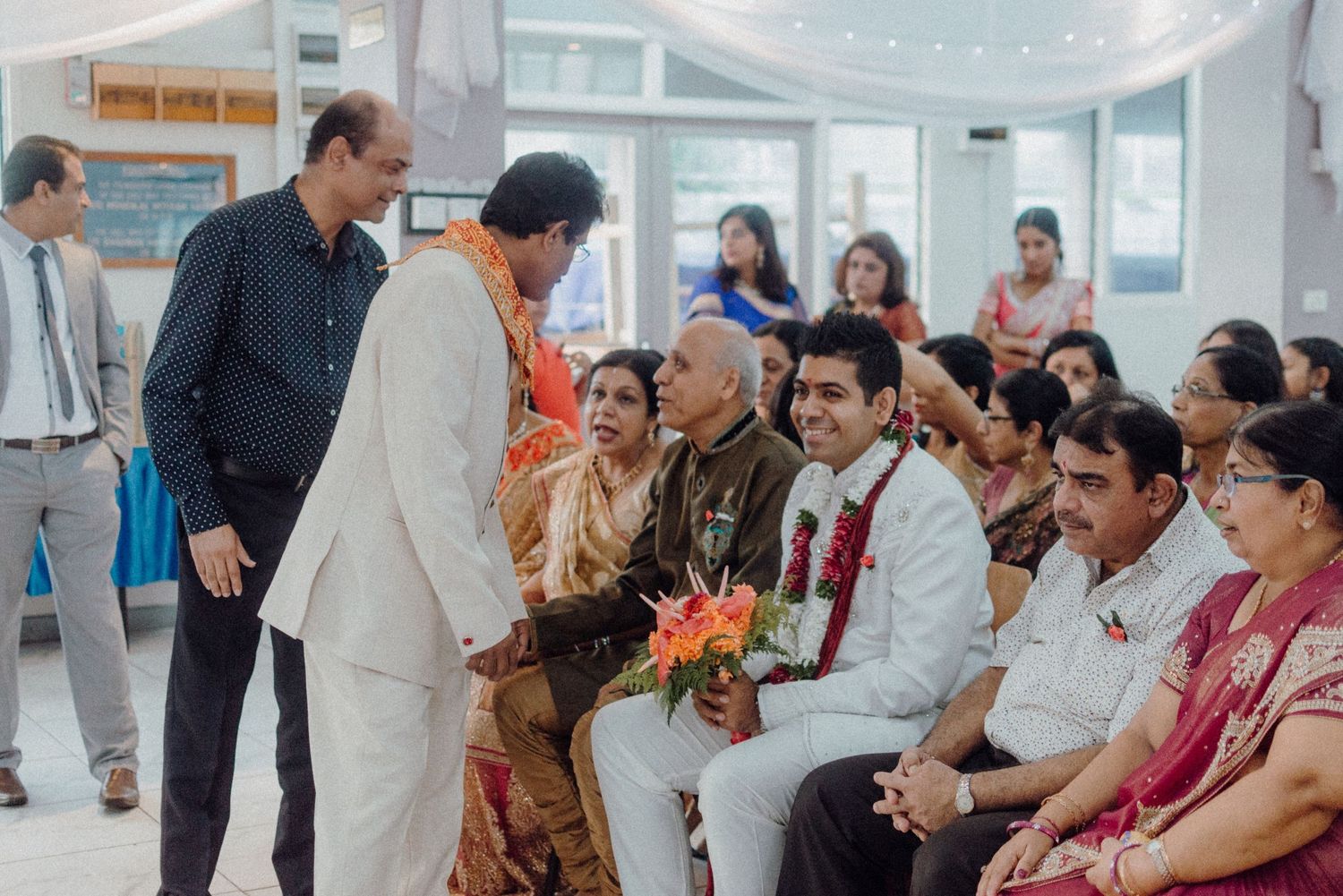 Wedding celebration showing guests and participants during a ceremonial moment.