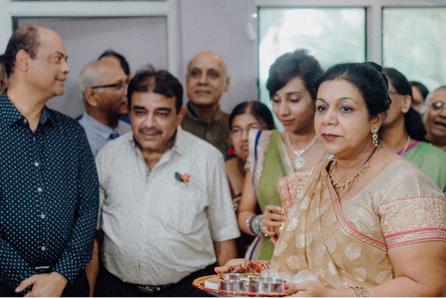 Guests gathered at a festive celebration wearing traditional Indian attire.