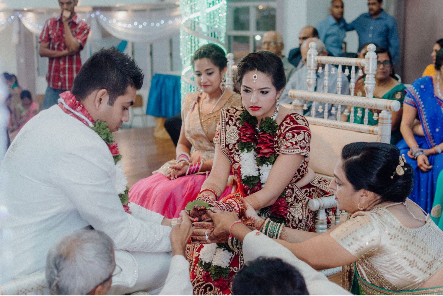 Wedding guests participating in traditional Indian ceremony rituals with offerings and blessings.