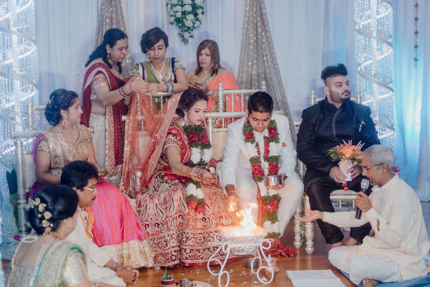 Wedding party performing ceremonial rituals with candles and offerings during an Indian celebration.