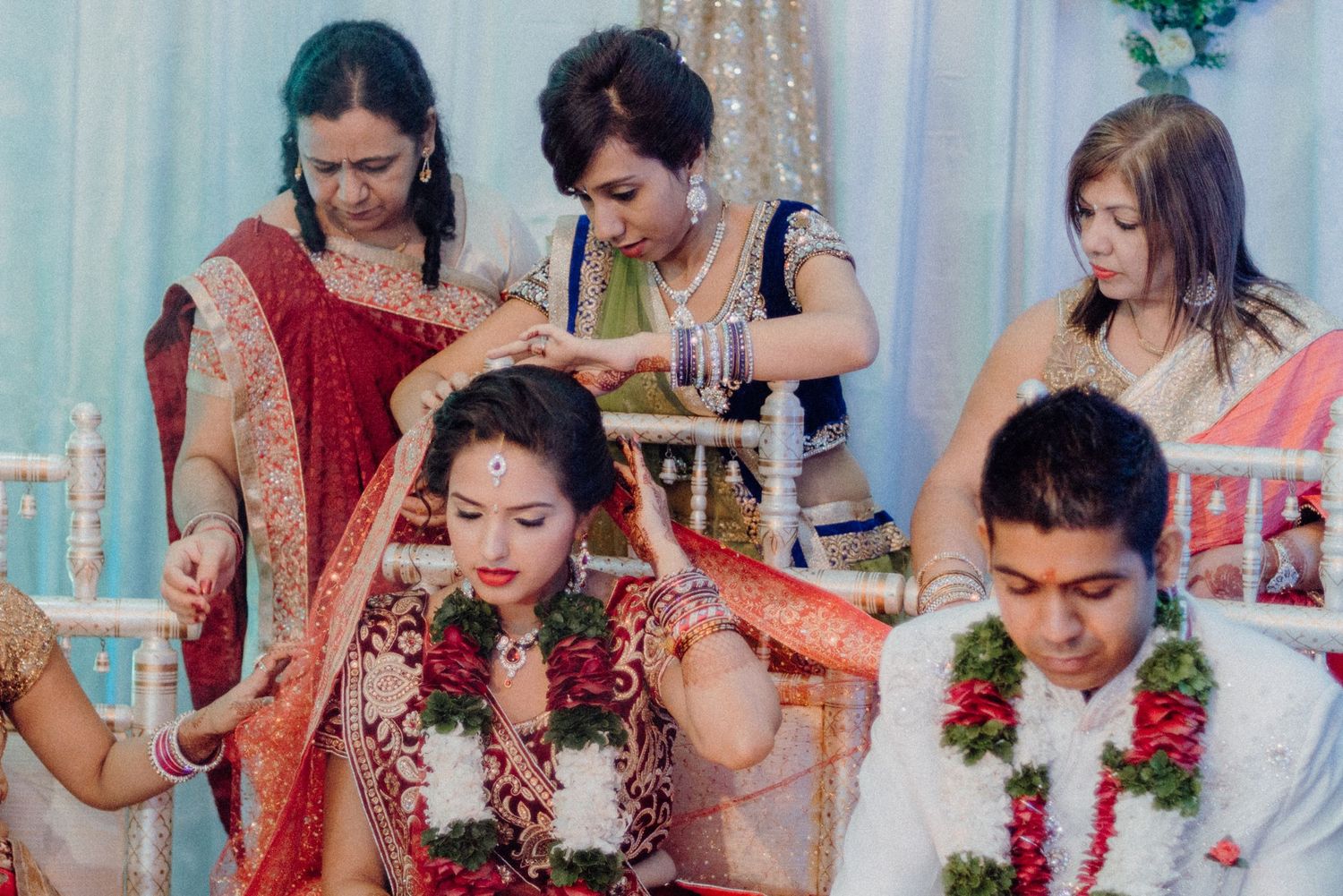 Guests help with traditional ceremonial preparations during an Indian wedding celebration.