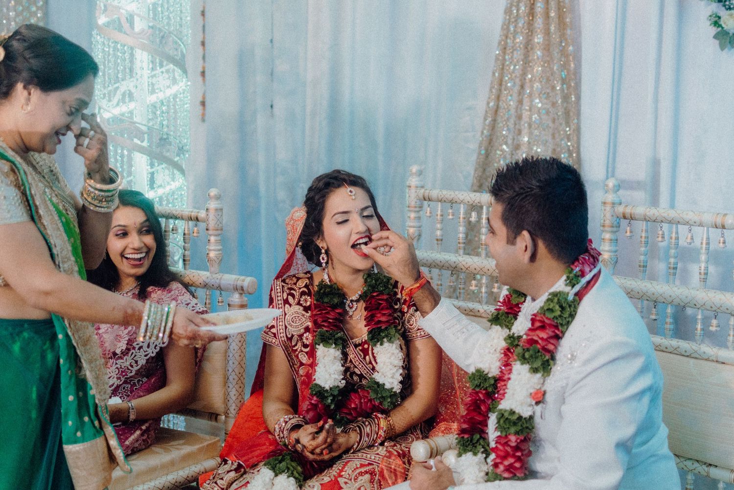 Joyful wedding ritual ceremony with participants in colorful traditional attire celebrating indoors.