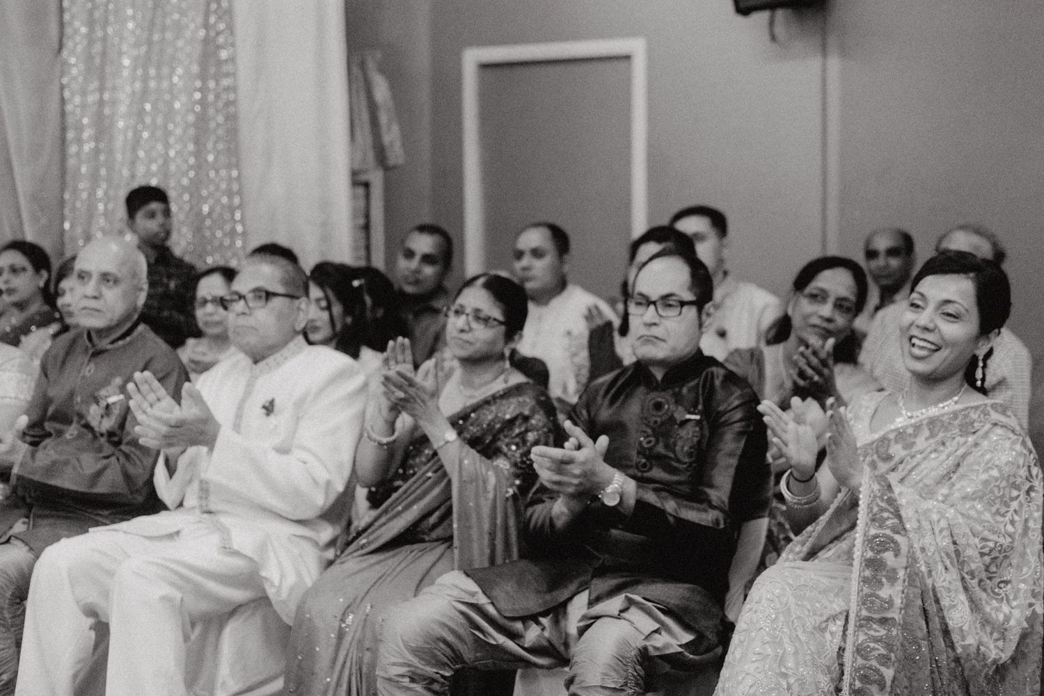 Black and white photo of wedding guests seated in rows during ceremony.
