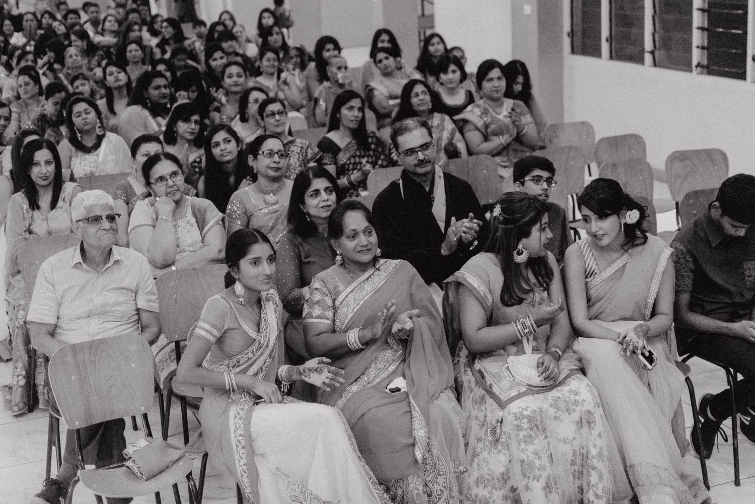 Vintage black and white photograph showing audience members seated at formal event.