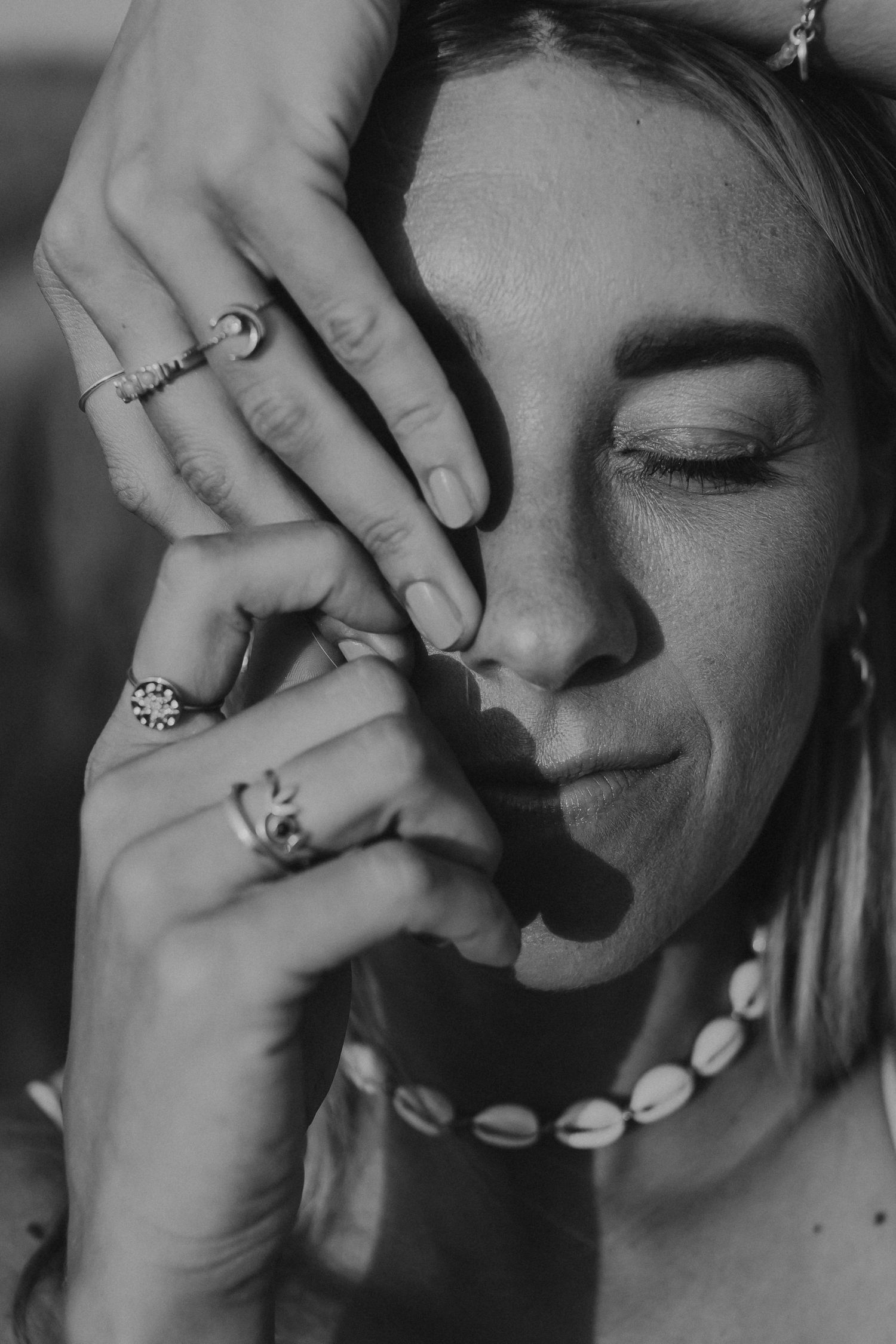 Black and white portrait showing jewelry and shell necklace details.