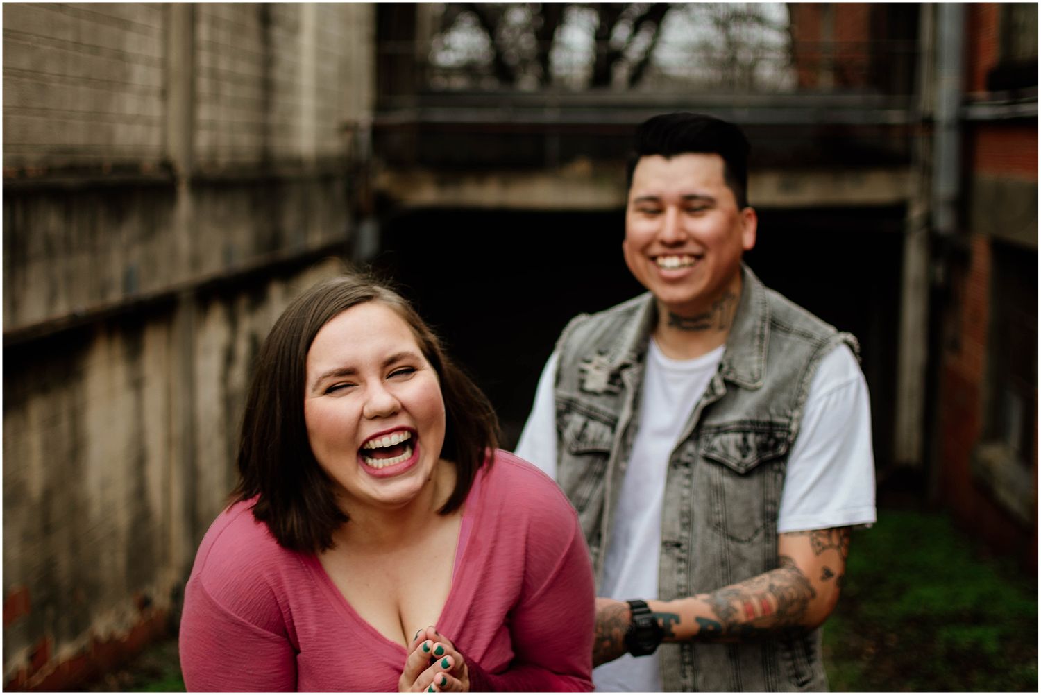 Joyful candid moment captured against urban brick wall background.