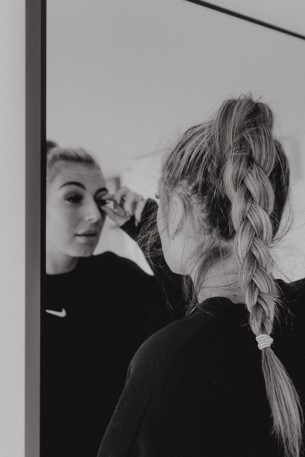 Reflection in mirror shows intricate braided hairstyle.