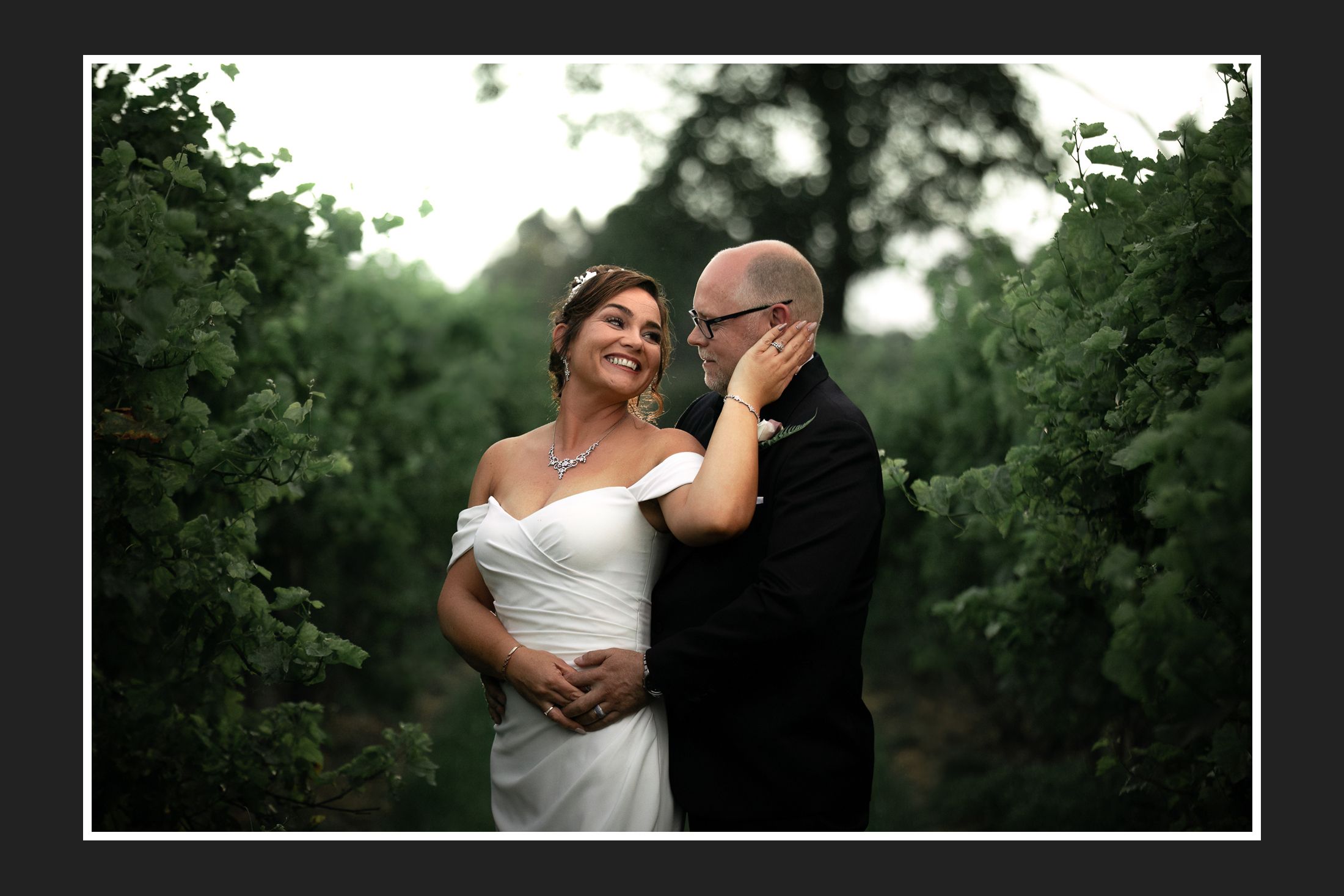 Romantic couple embracing in a lush garden setting during their wedding day.