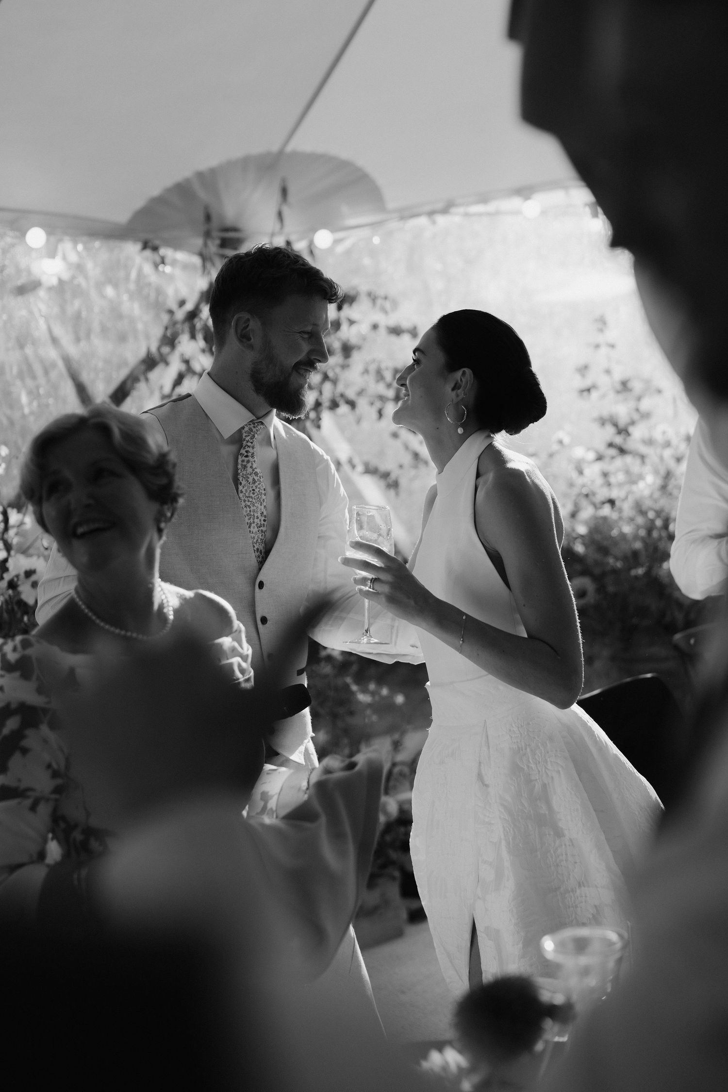 bride and groom leaning in for a kiss after his speech in marquee in islip in oxfordshire