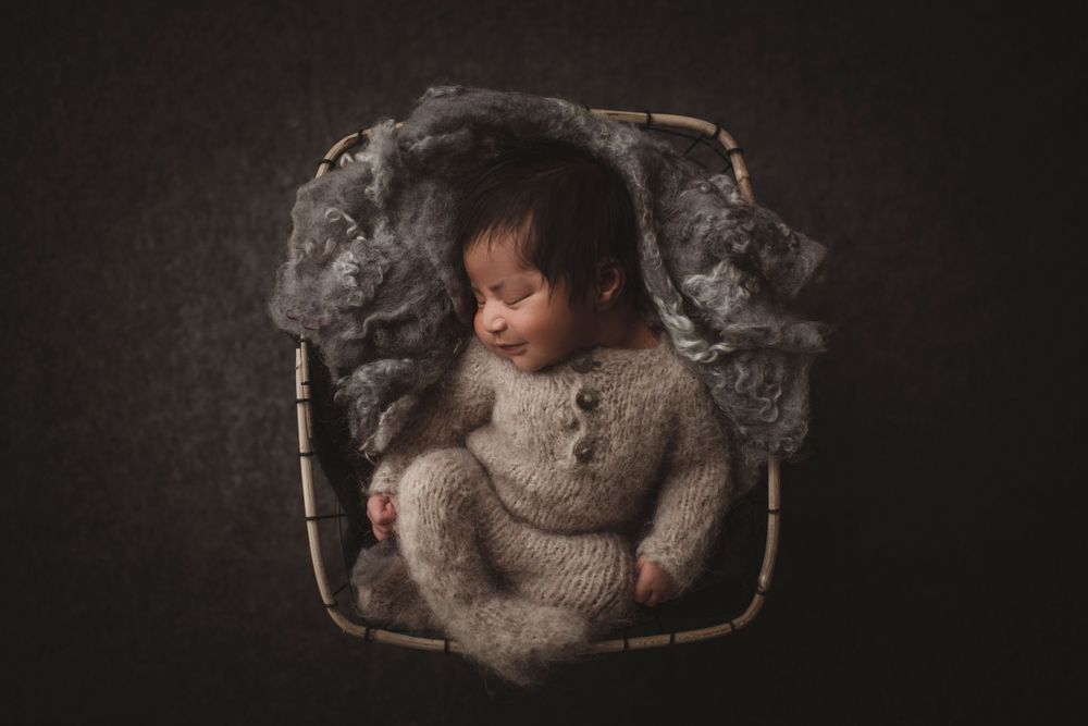 nyfødtfotografering-smilende nyfødt i kurven
