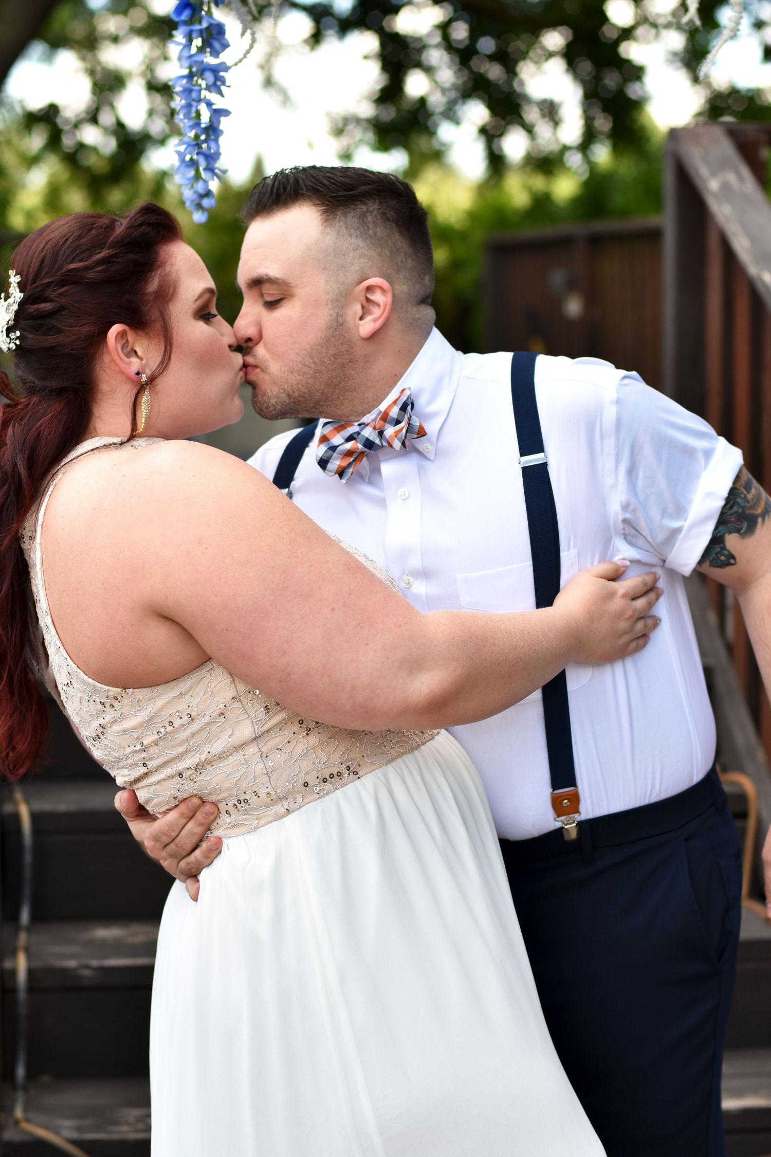Newly married couple kissing under flowers