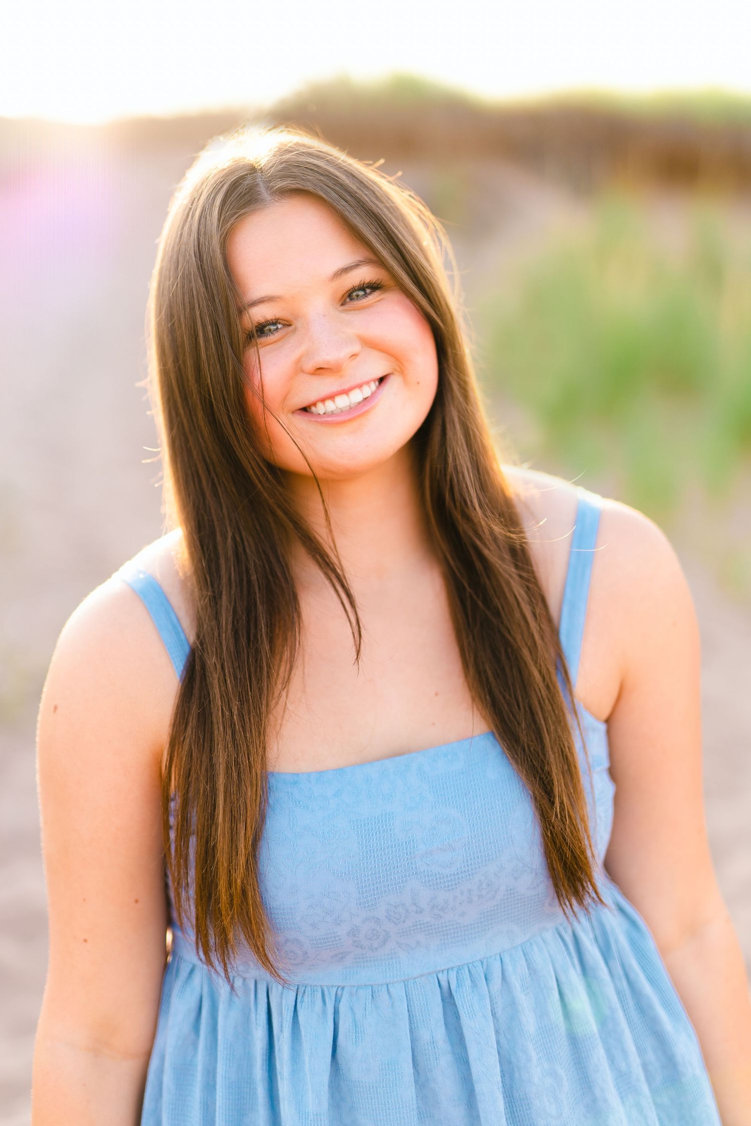 Portrait of a young woman in a blue dress during golden hour.