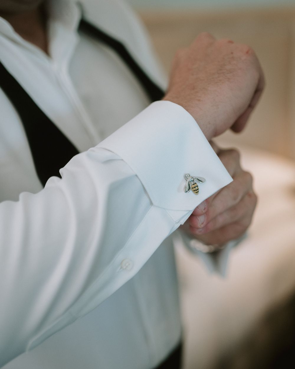 Close-up of white dress shirt cuff with silver cufflink detail.