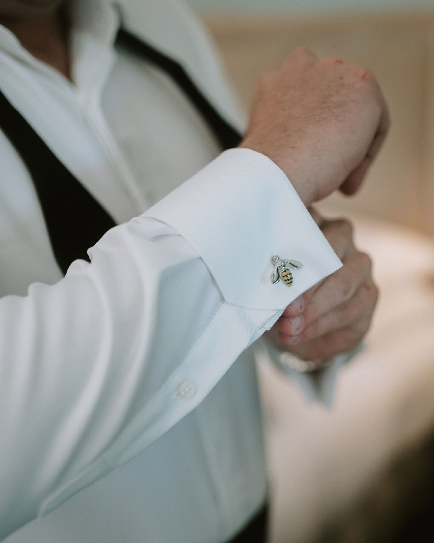 Close-up of white dress shirt cuff with silver cufflink detail.