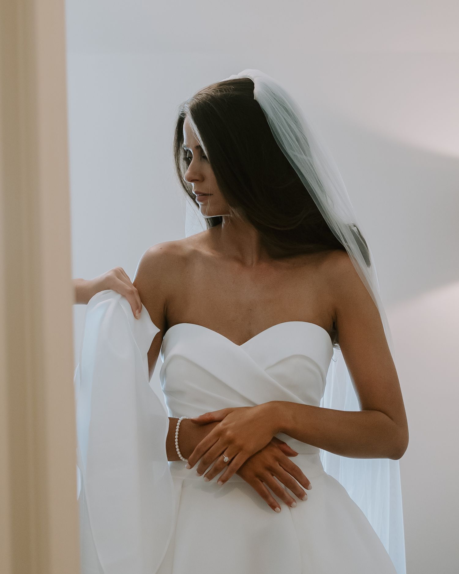 Elegant bridal portrait in a strapless white wedding gown with veil.