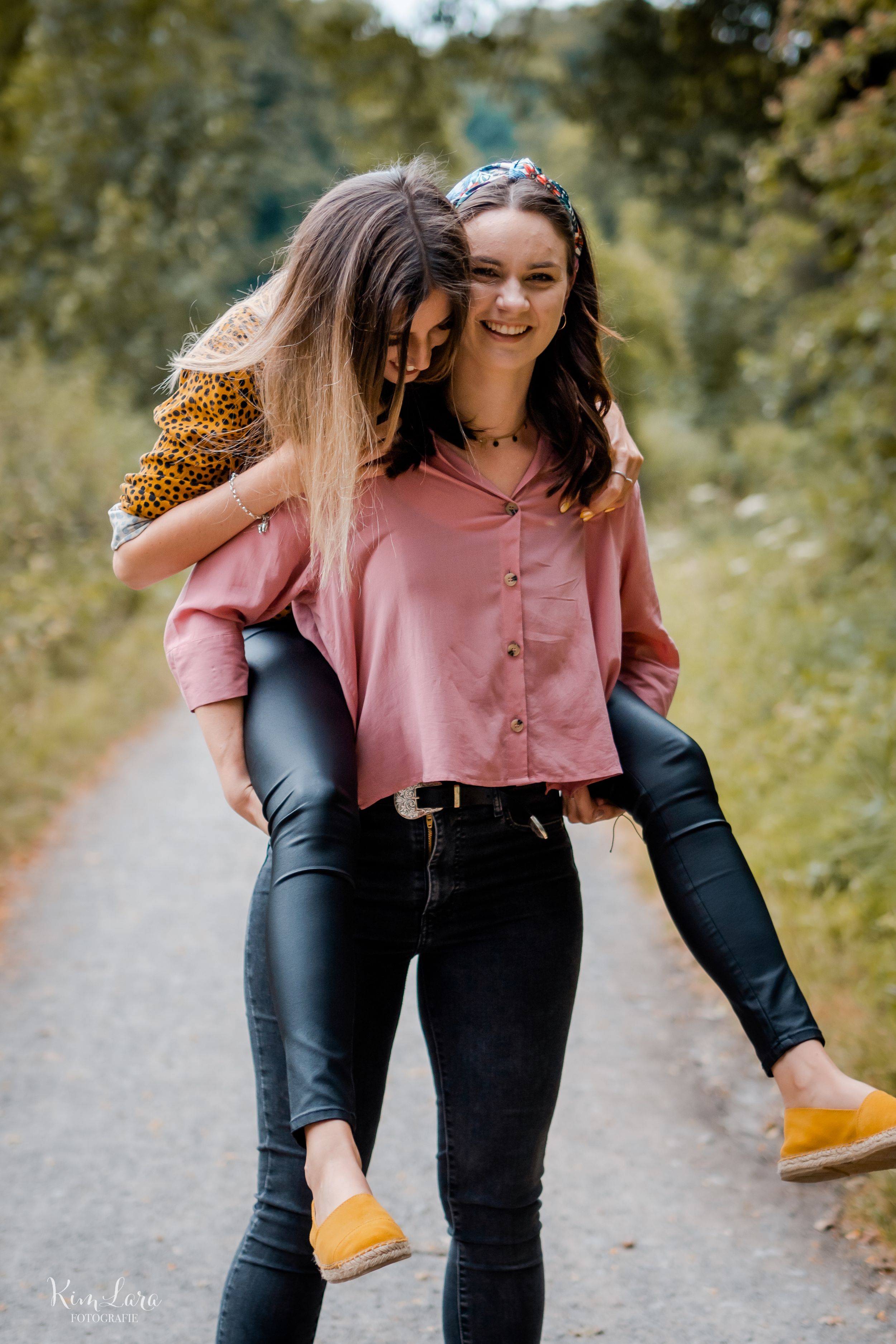 Freundinnen lachen beim Huckepack