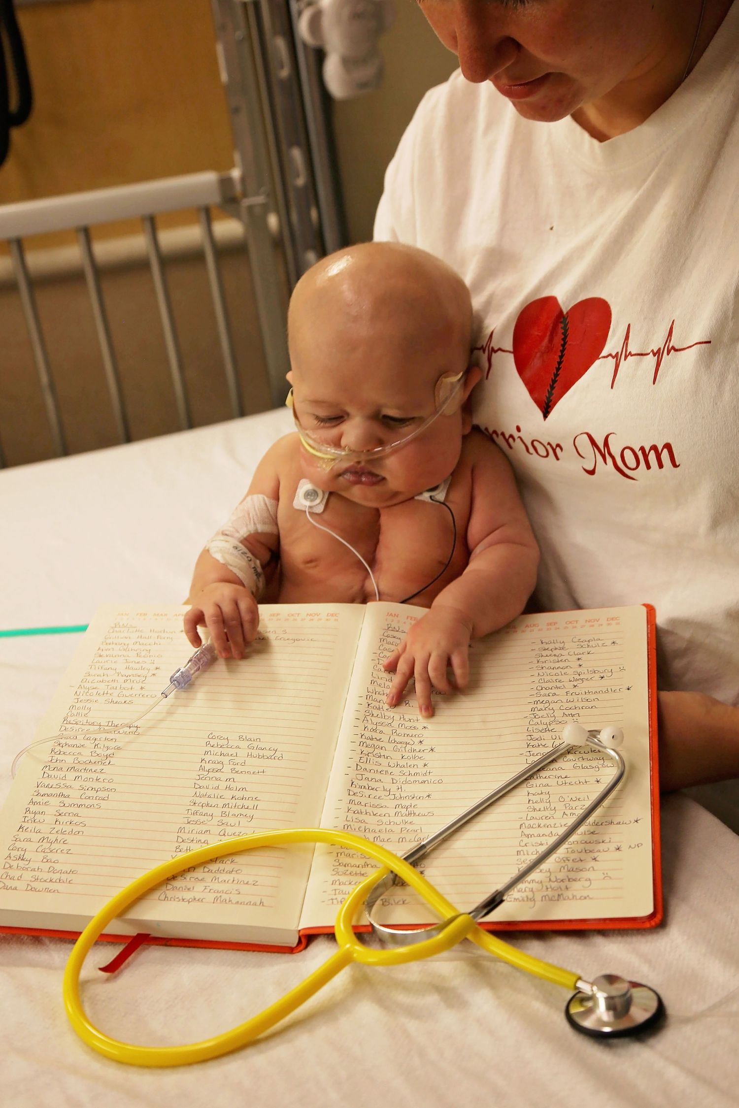 baby looking at all his nurses names in book