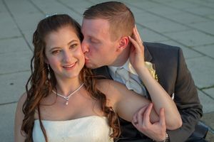 Wedding couple shares intimate moment outdoors during golden hour photography session.