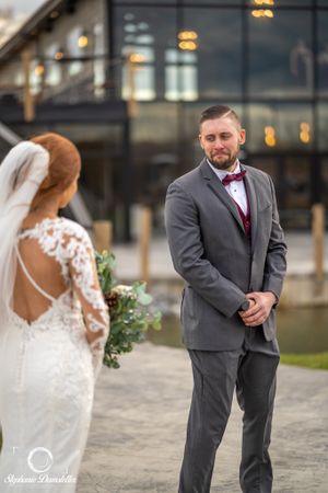 First look moment between wedding couple outside modern building.