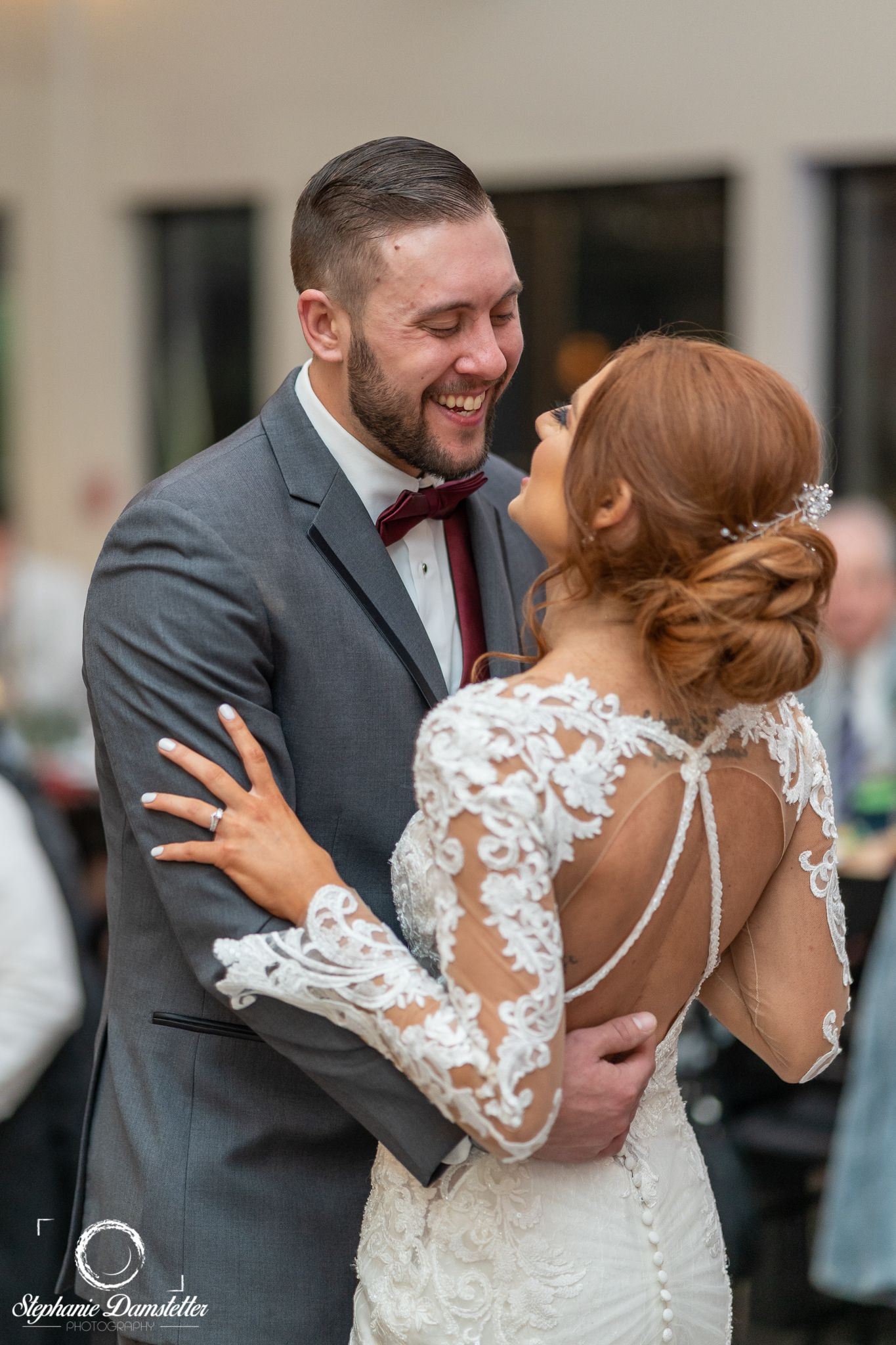 A joyful wedding couple sharing a candid moment during their first dance.
