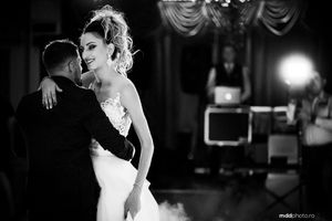 Black and white photo of couple dancing at wedding reception.