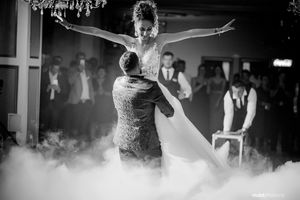 Dramatic black and white photo of couple dancing in fog during first dance.
