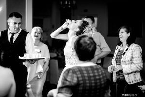 Black and white candid wedding reception moment showing guests laughing and enjoying themselves.