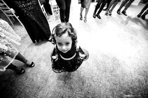 Black and white overhead shot of a young attendee in a formal dress at an event.