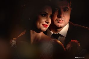 Dramatic low-key portrait of a couple in formal attire creating moody atmosphere.