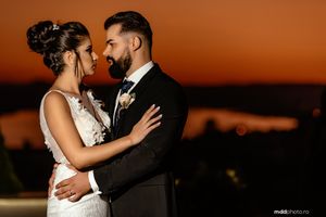 Intimate wedding portrait captured during golden hour sunset with dramatic lighting.