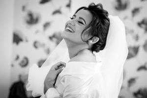 Black and white portrait showing joyful laughter against a patterned backdrop.