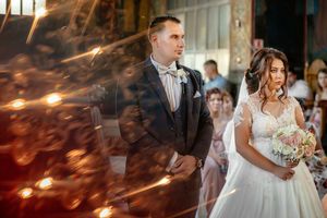 Artistic wedding ceremony photo with dramatic lighting effects and bokeh.