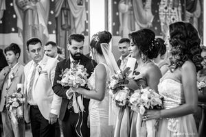 Black and white wedding party photo showing bridal party lineup with bouquets.