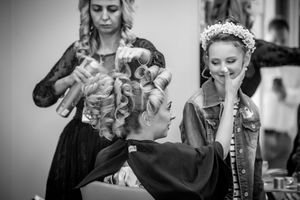 Black and white photo of wedding preparation with denim jacket and floral crown.