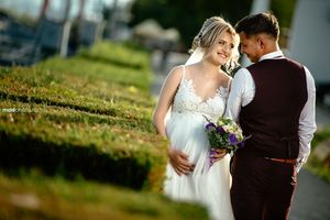Romantic wedding portrait of couple in garden setting during golden hour.