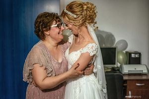 Emotional pre-wedding moment between bride and loved one sharing an intimate embrace.
