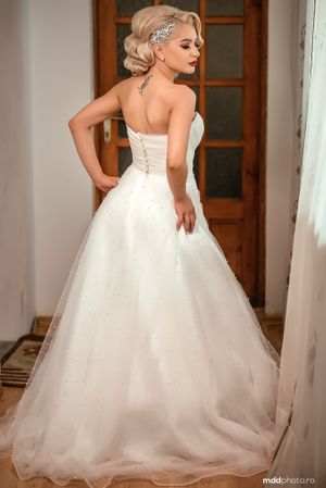Back view of princess wedding gown with corset detail and flowing tulle skirt.